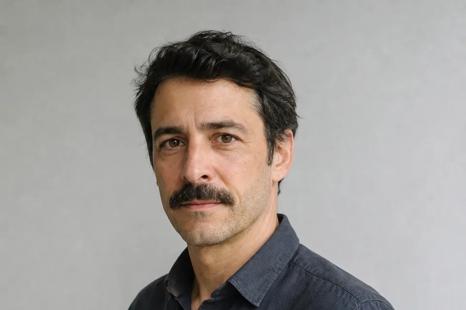 Rodrigo Arranz, responsable de la tienda, con camisa azul oscuro ante una pared gris clara